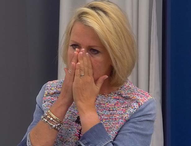 Eine Frau mit blonden Haaren hält ihre Hände vor ihr Gesicht, möglicherweise weinend.