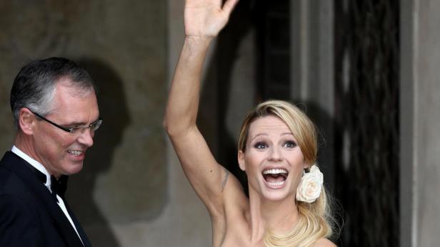 Michelle Hunziker strahlt und winkt mit erhobenem Arm.