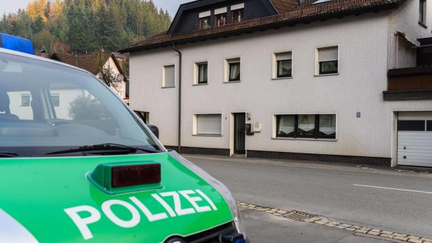 Ein Streifenwagen der Polizei steht vor einem Wohnhaus.