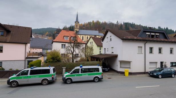 Zwei Polizeiwagen stehen in einer ruhigen Wohngegend.