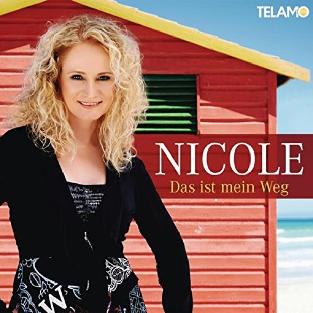 Das Cover des Albums „Das ist mein Weg“ von Nicole zeigt die Sängerin vor einem roten Strandhaus.