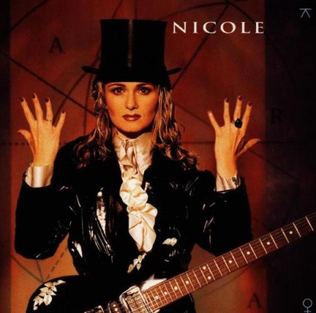 Nicole in einem schwarzen Anzug und Zylinder mit einer E-Gitarre.