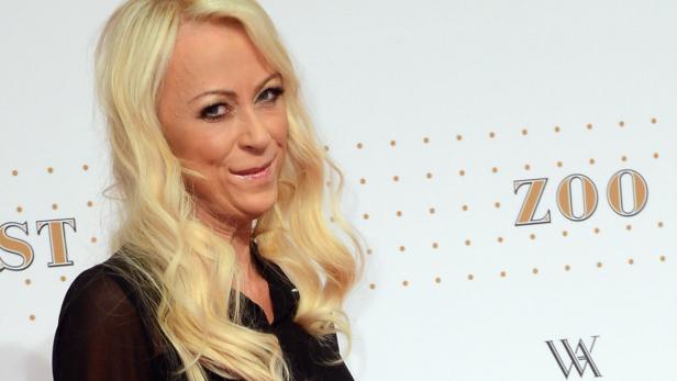 Jenny Elvers posiert vor einer Wand mit der Aufschrift „Zoo“.