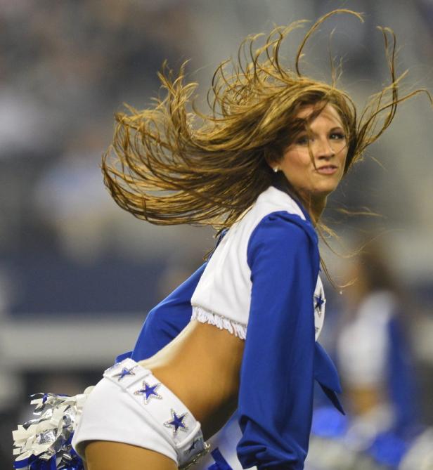 Eine Cheerleaderin der Dallas Cowboys wirft ihr Haar nach hinten.