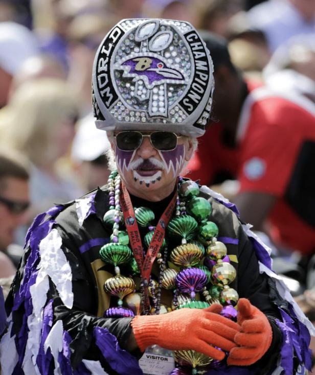Ein Fan der Baltimore Ravens mit Gesichtsbemalung und einem übergroßen Ring-Hut.