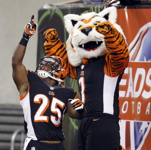 Ein Footballspieler der Cincinnati Bengals jubelt neben dem Maskottchen der Mannschaft.