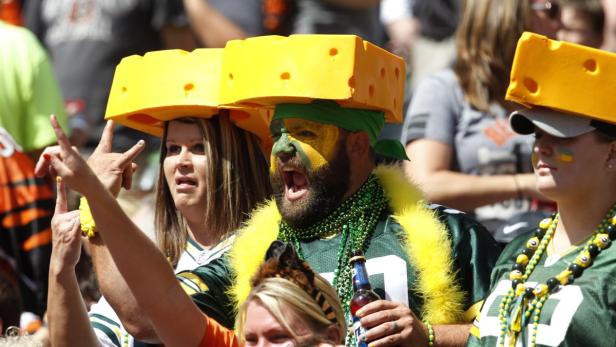 Fans der Green Bay Packers mit Käsehut und Gesichtsbemalung feuern ihr Team an.