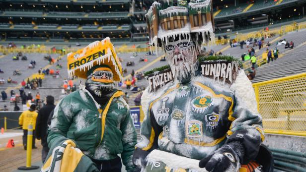 Zwei Green Bay Packers-Fans in fantasievollen, eisbedeckten Kostümen bei einem Footballspiel.