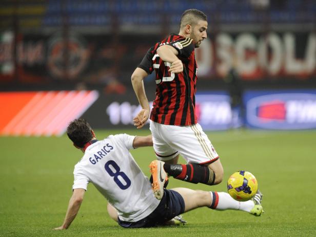 AC Milan's Adel Taarabt fights for the ball with Bologna's Gyorgy Garics during their Italian Serie A soccer match in Milan