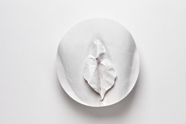 Ein zerknittertes Papierblatt liegt auf einem weißen Pappteller.