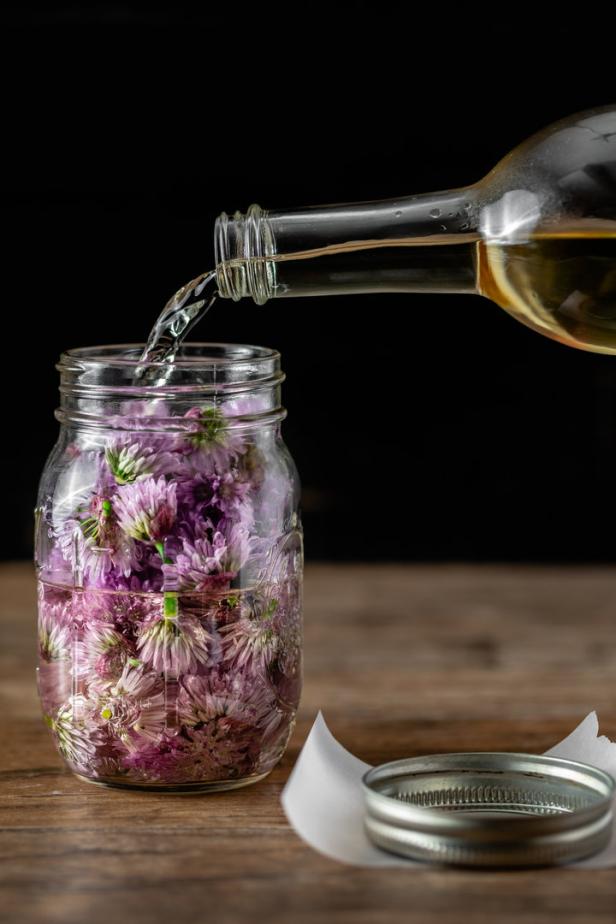 Schnittlauchblüten-Essig wird in einem Einmachglas hergestellt