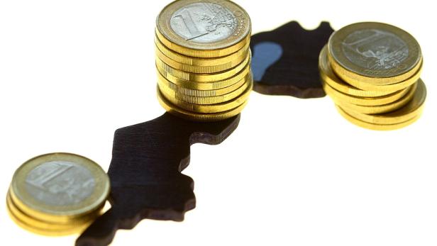 Euro-Münzen liegen auf einer dunklen Silhouette des afrikanischen Kontinents.
