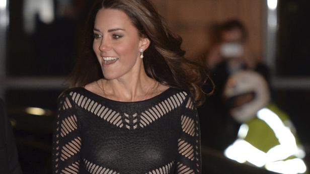 Catherine, Princess of Wales, lächelt in einem schwarzen Kleid.