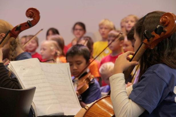 Ein Orchester von Kindern spielt Geige und Cello.