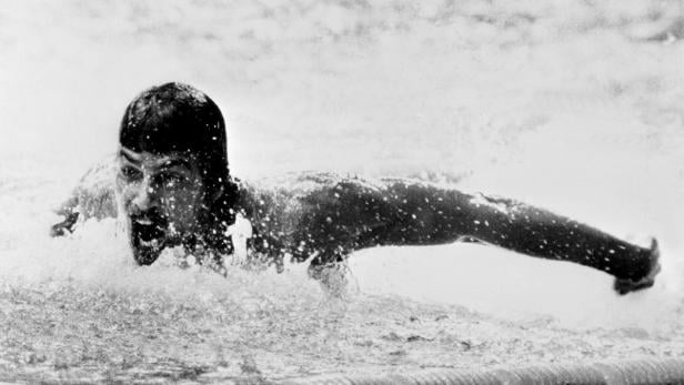 Ein Schwimmer beim Schmetterlingsstil im Wasser.