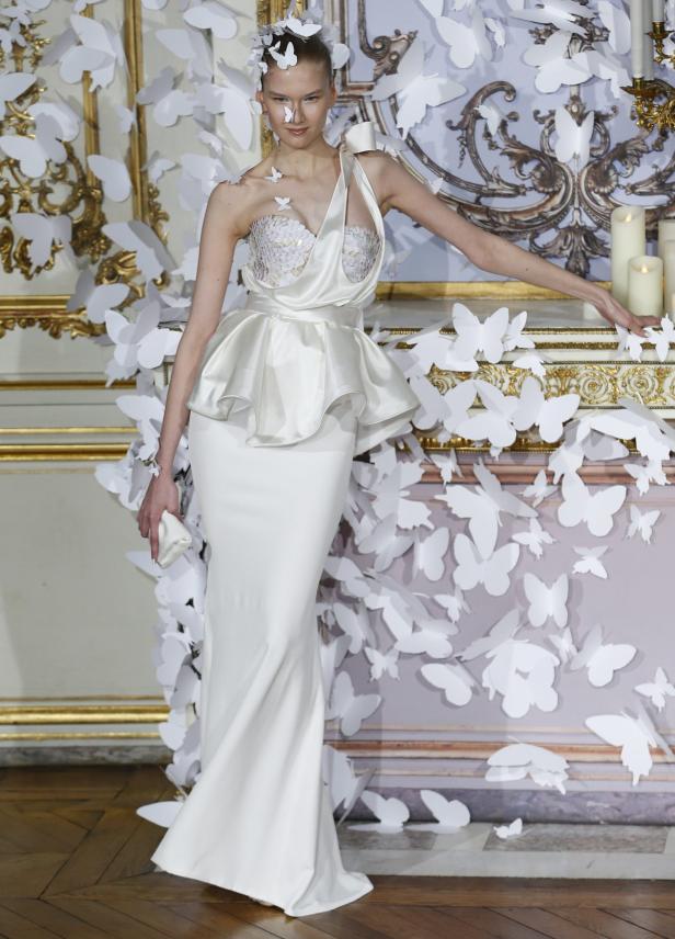 Eine Frau in einem weißen Kleid, umgeben von weißen Papier-Schmetterlingen.