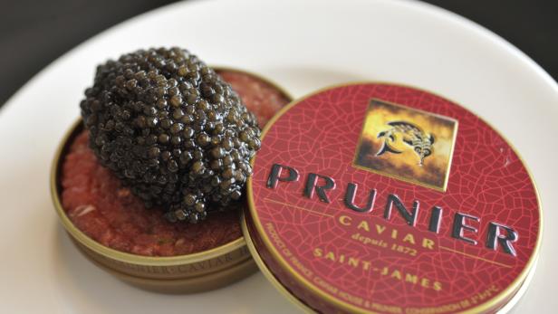 Eine Dose Prunier Kaviar mit einer Portion Kaviar auf einem Teller.