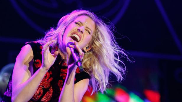 Ellie Goulding singt während eines Konzerts ins Mikrofon.
