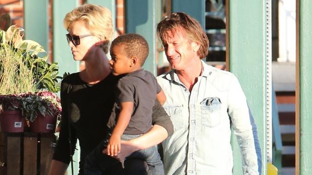Charlize Theron und Sean Penn mit einem Kind im Arm.