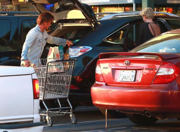 Sean Penn packt Einkäufe in den Kofferraum eines Autos.