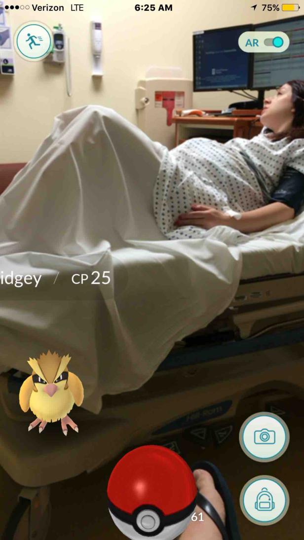 Eine Frau liegt in einem Krankenhausbett, während im Vordergrund ein Pokémon-Spiel läuft.