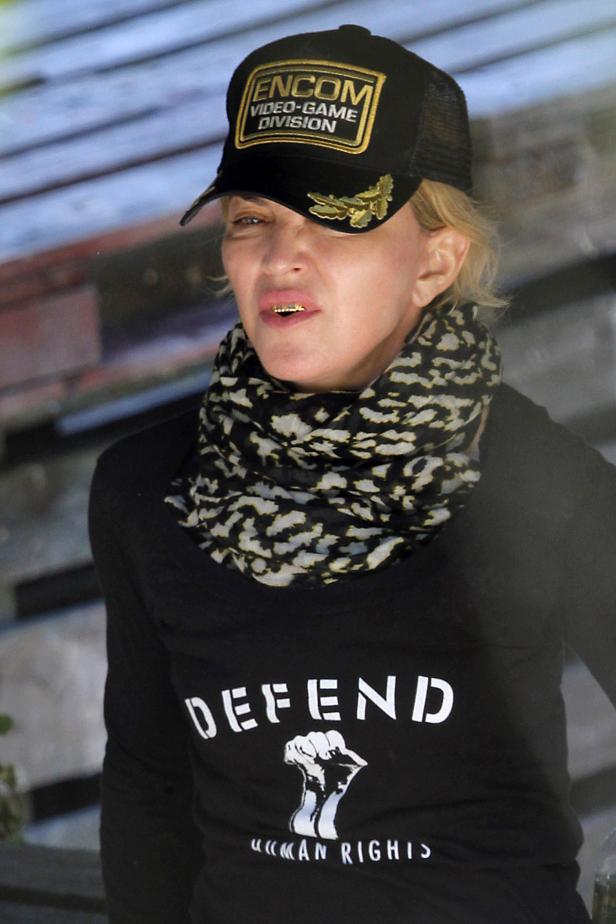 Madonna trägt eine Kappe mit der Aufschrift „ENCOM Video-Game Division“ und ein T-Shirt mit der Aufschrift „Defend Human Rights“.