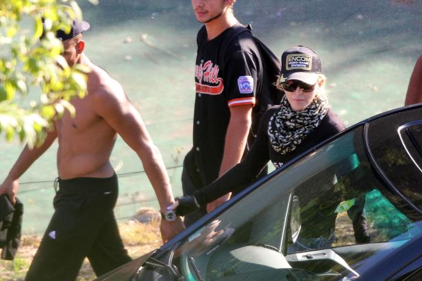 Madonna steigt in ihr Auto, begleitet von zwei Männern.