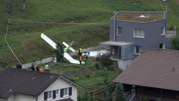 Ein abgestürztes Kleinflugzeug liegt in einem Garten neben Wohnhäusern.
