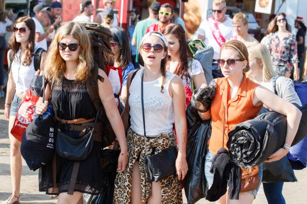 Eine Gruppe junger Frauen mit Gepäck auf einem Festivalgelände.
