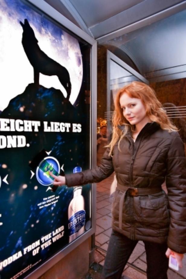 Eine Frau interagiert mit einem interaktiven Werbeplakat für Eristoff Vodka.