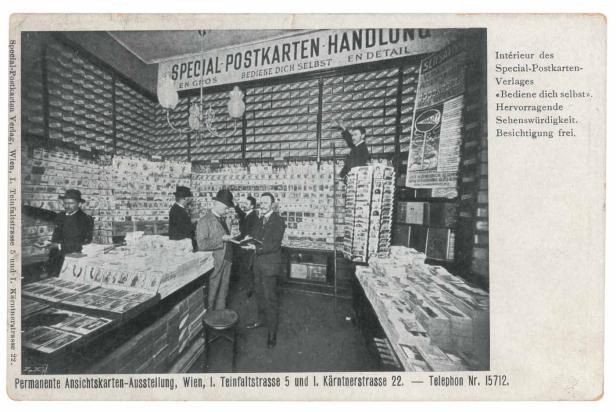 Das Innere eines historischen Postkartenladens in Wien mit Kunden und einem Angestellten auf einem Stapel Postkarten.