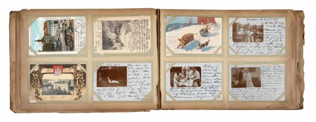 Ein geöffnetes Fotoalbum mit alten Fotos und Postkarten aus der Zeit um 1900.