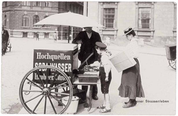 Ein Junge kauft an einem Soda-Stand auf der Straße ein Getränk.