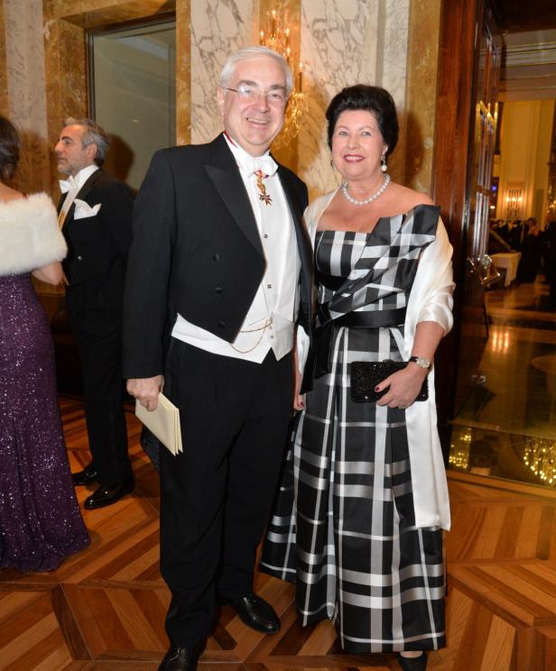 Ein Mann im Smoking und eine Frau im schwarz-weiß karierten Kleid posieren für ein Foto.