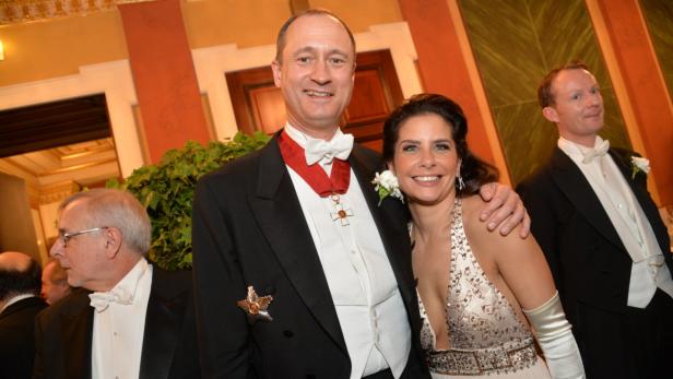 Ein Mann mit Auszeichnungen und eine Frau in Abendgarderobe posieren für ein Foto.
