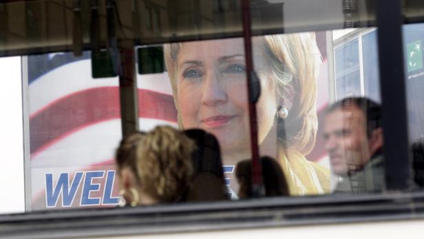 Ein Wahlplakat mit dem Bild von Hillary Clinton, gesehen durch ein Busfenster.