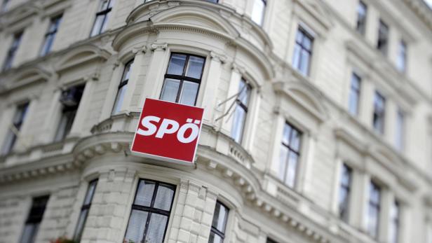Ein rotes Schild mit dem Logo der SPÖ hängt an einer Gebäudeecke.