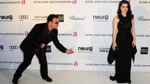 Musician Bono and his daughter Hewson arrive at th Bono posiert mit einer Frau in einem schwarzen Kleid auf dem roten Teppich einer Gala der Elton John AIDS Foundation.