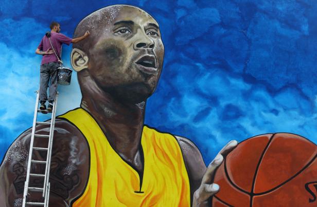 Artist Deni Bozic (27) paints the last details on his tribute mural honoring former Los Angeles Lakers basketball star Kobe Bryant on a school building wall in Gradiska