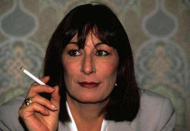 Anjelica Huston hält eine Zigarette in der Hand.
