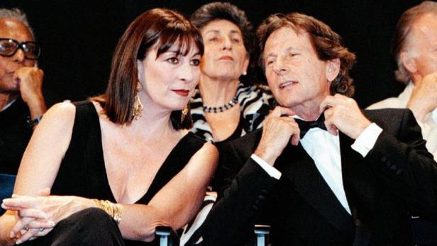 Anjelica Huston und Jack Nicholson sitzen bei einer Veranstaltung nebeneinander.