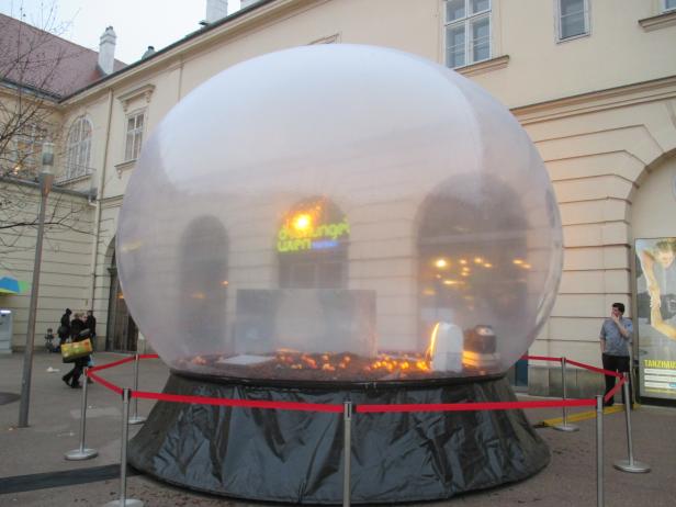 Eine große, transparente Kugel steht vor einem Gebäude in Wien.