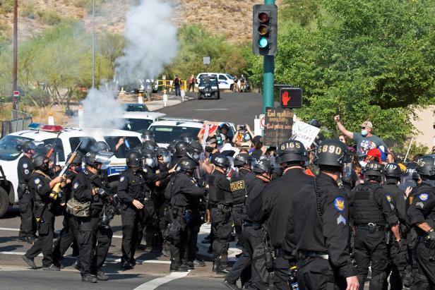 Police fire crowd control weapons during the visit by U.S. President Donald Trump to the Dream City Church in Phoenix