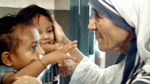 Mutter Teresa interagiert mit zwei kleinen Kindern.