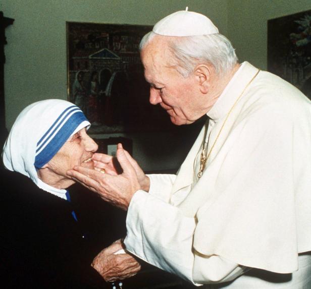 Papst Johannes Paul II. berührt das Gesicht von Mutter Teresa.