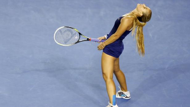 Eine Tennisspielerin mit blondem Pferdeschwanz blickt nach einem Schlag nach oben.
