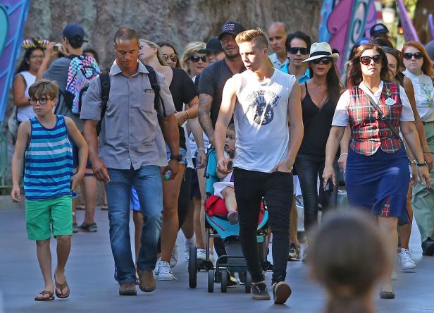 Die Familie Beckham geht in einem Freizeitpark spazieren.