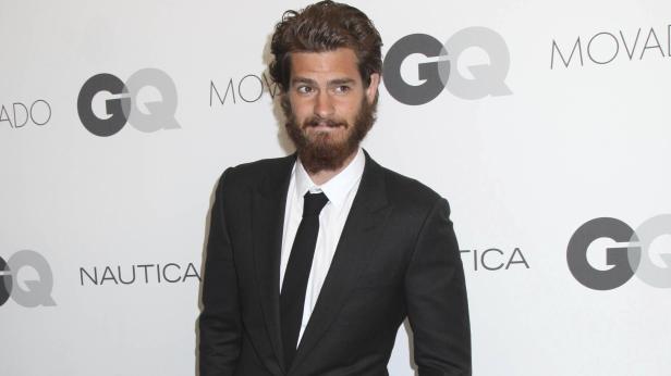 Andrew Garfield posiert vor einem Hintergrund mit GQ-Logos.