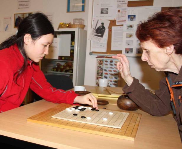 Zwei Frauen spielen das Brettspiel Go.