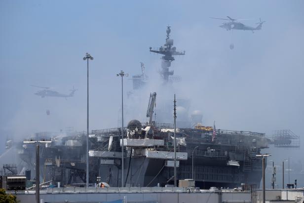U.S. Navy helicopters continue fighting a fire on the amphibious assault ship USS Bonhomme Richard at Naval Base San Diego